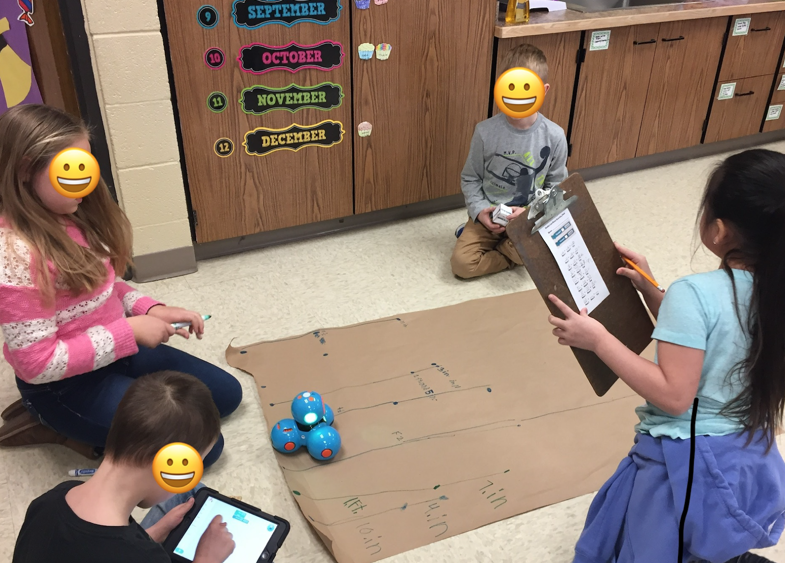 Four kindergarteners use collaboration to guide the robot