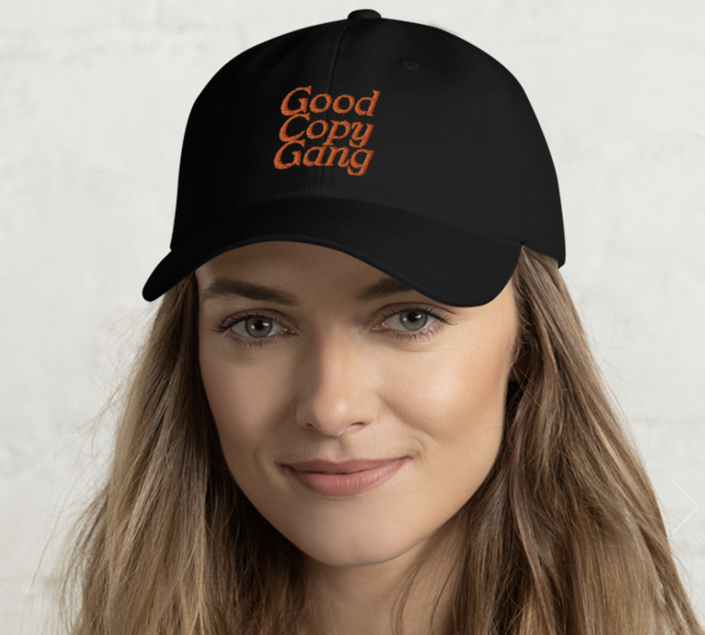 photo of a woman wearing a black hat with orange letters that reads "Good Copy Gang"