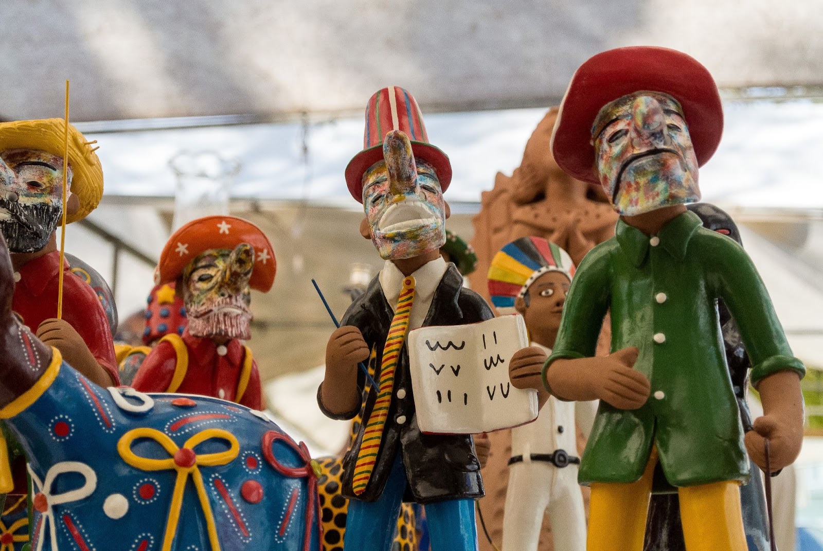 Estatuetas de barro expostas em museus em Recife. Elementos típicos da arte popular nordestina, elas representam figuras humanas e animais com traços fantasiosos e cores vibrantes.