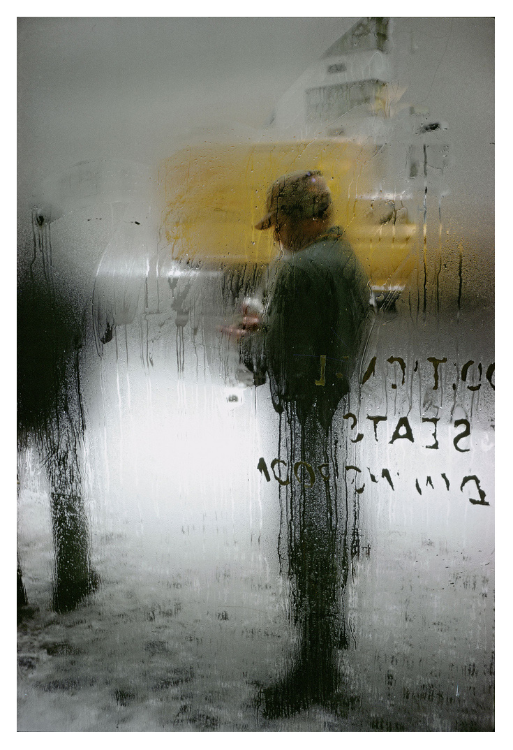 An image of a man stood in front of a steamy window by Saul Leiter