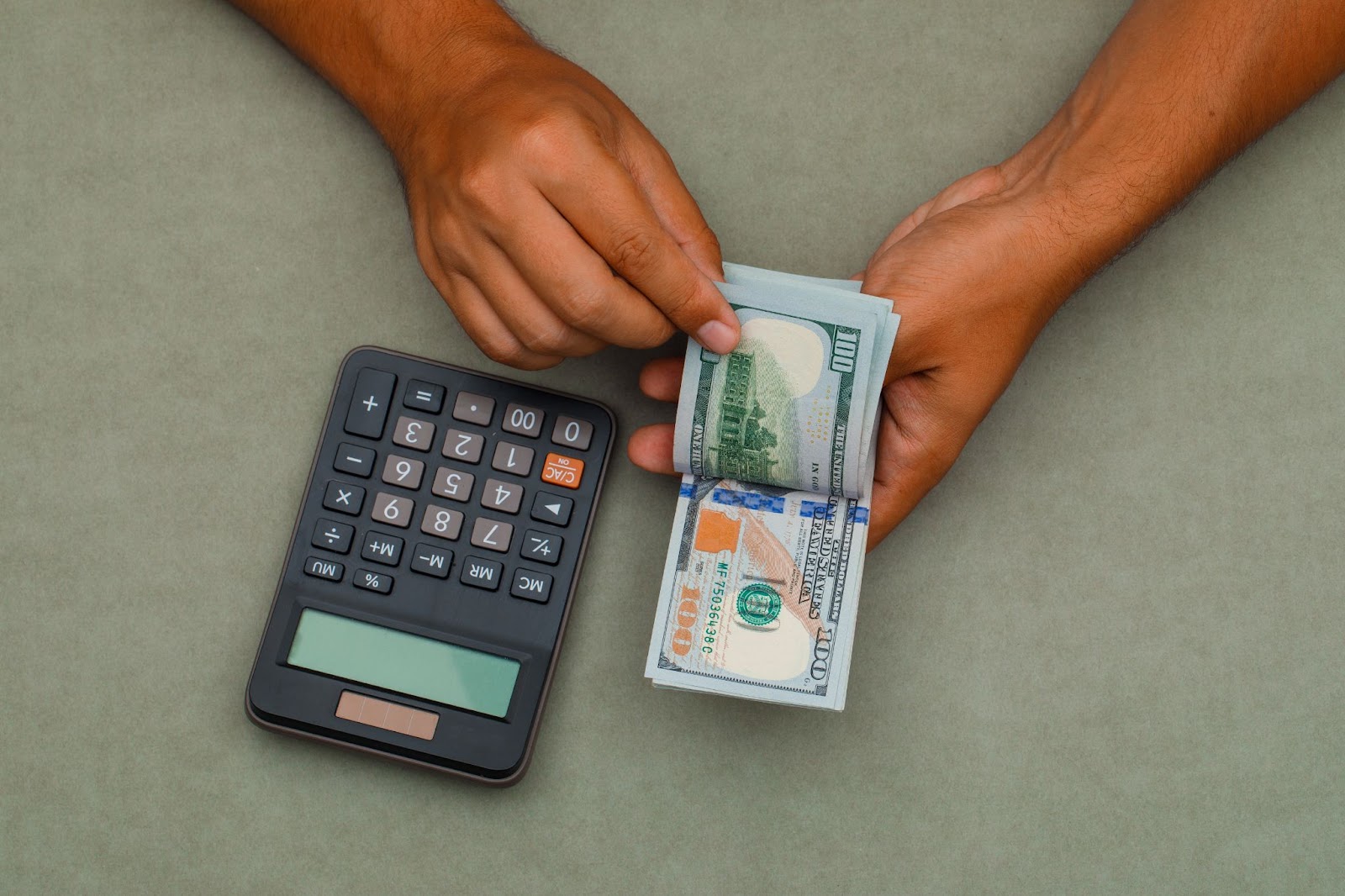 calculator-green-grey-table-man-counting-dollar-bills
