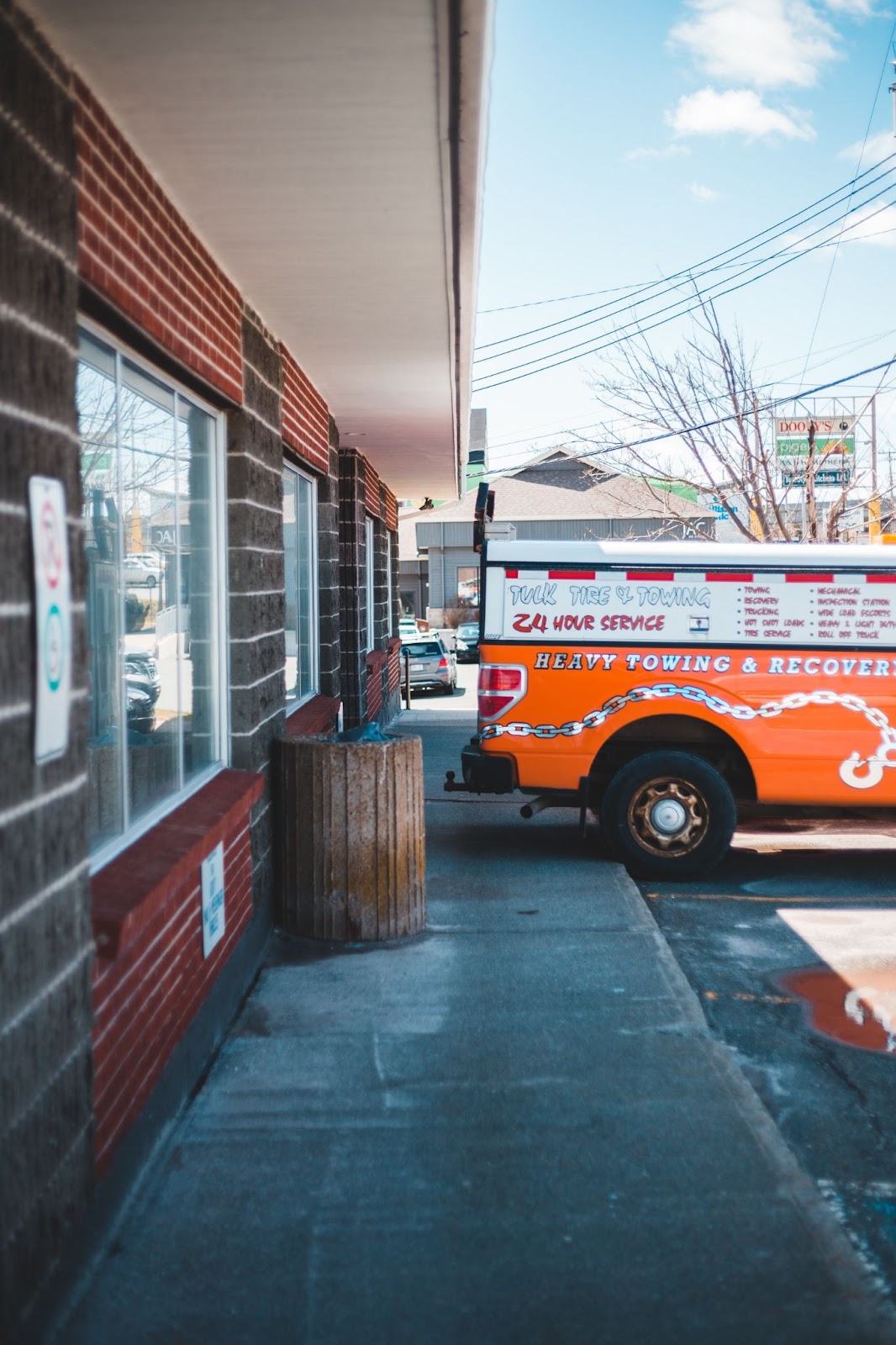 A tow truck parked against a storefront