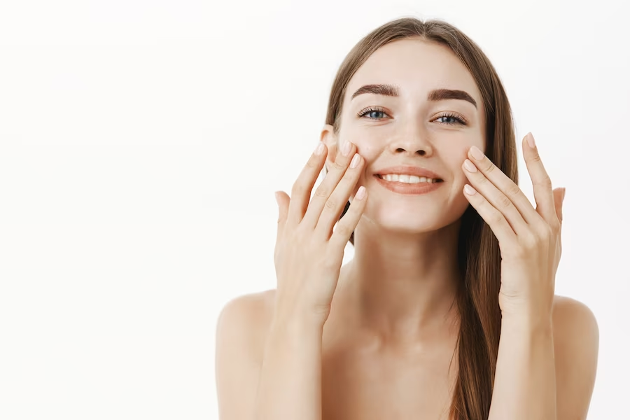 A woman applying facial cream to her face