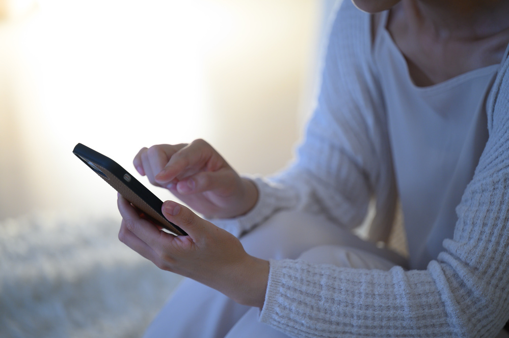 スマホで計算をしている女性