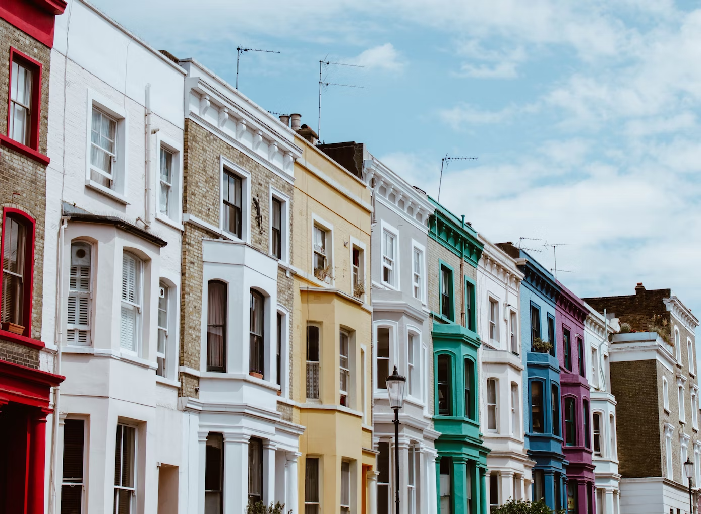 A row of colourful terraced houses for sale or rent.
