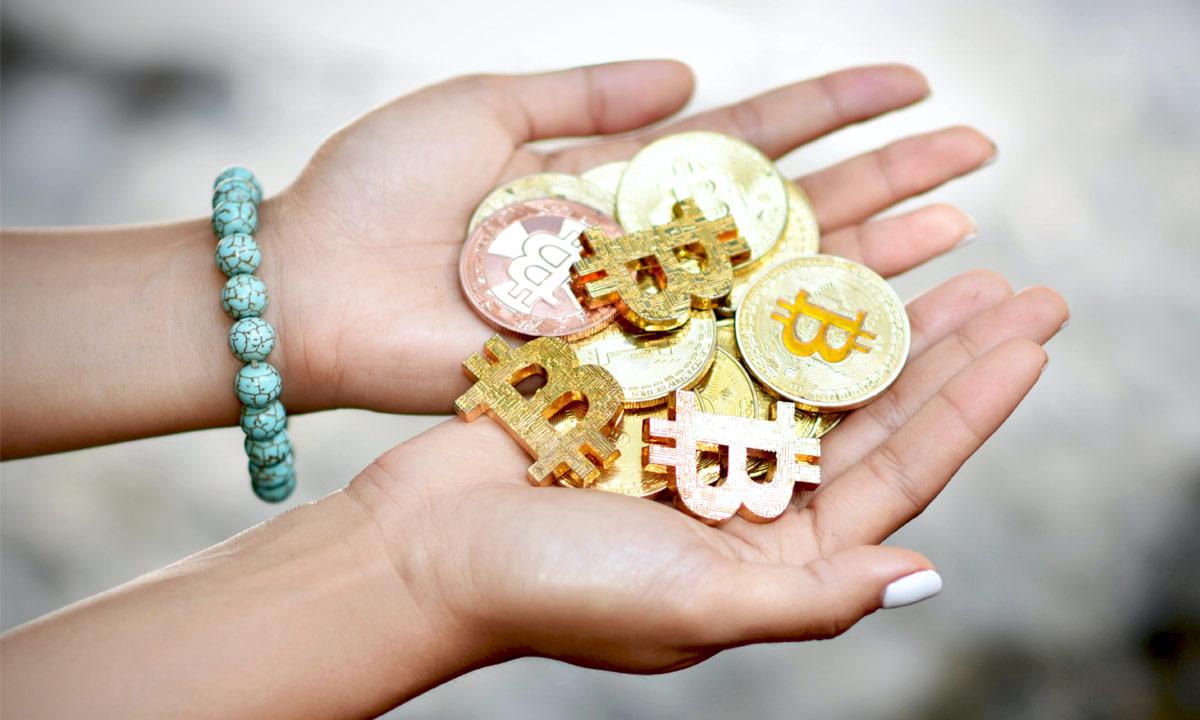 Female hands holding a range of crypto coins