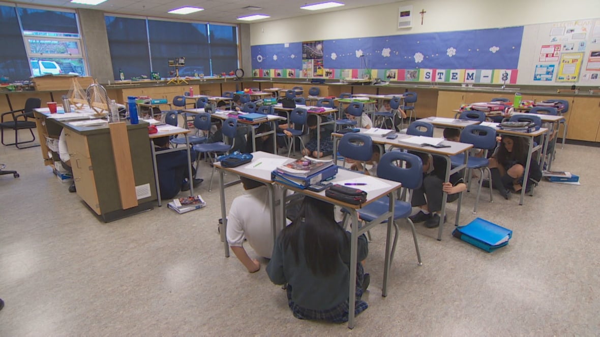 Grade 8 students at the Notre Dame Regional Secondary School practice how to react to an earthquake early warning alarm. (Photo from the CBC.)