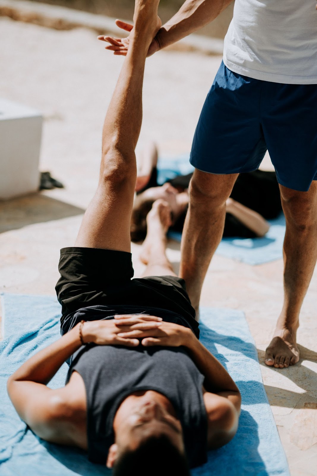 a man laying on ground and lifting up the leg with gym clothes