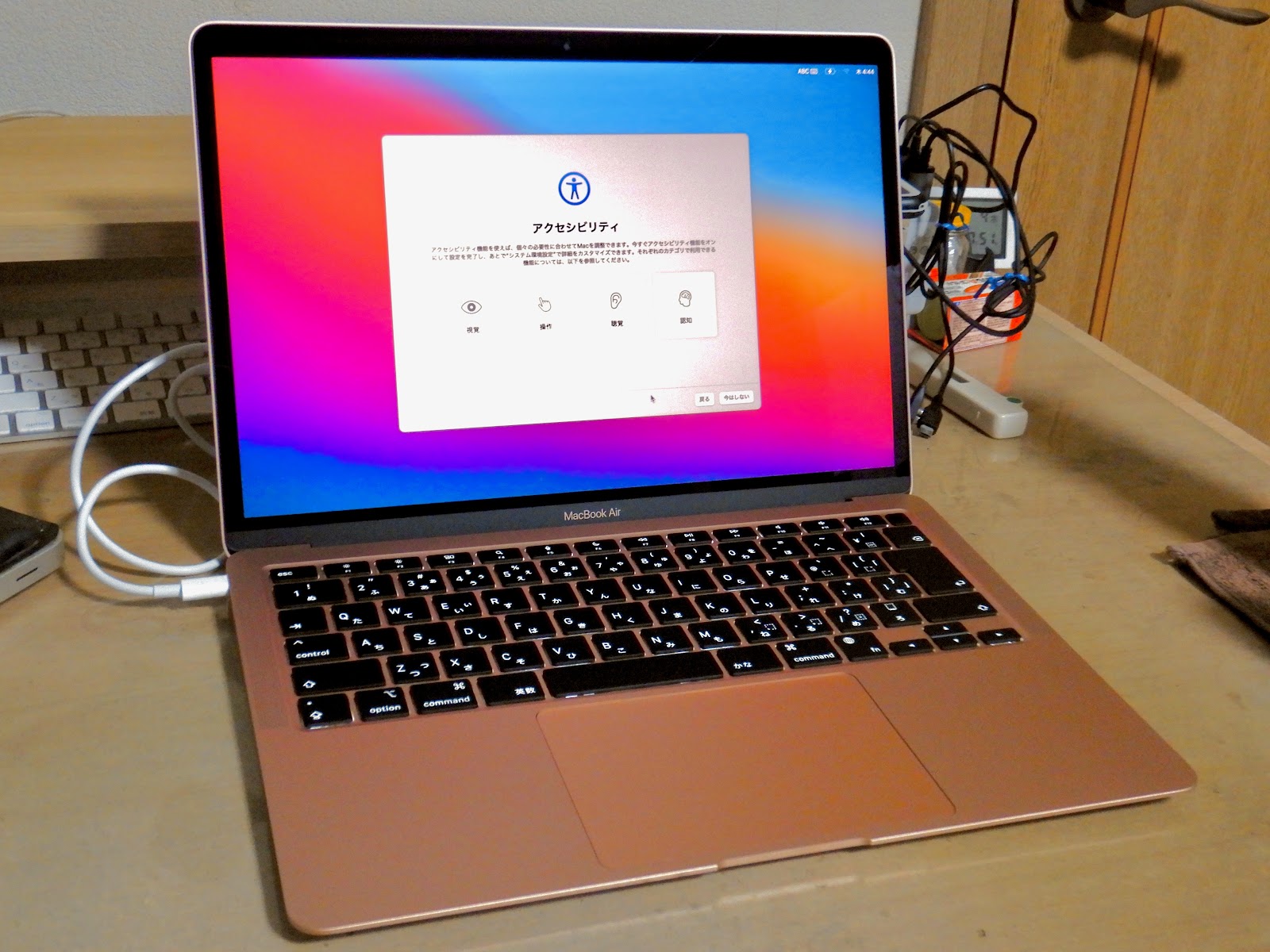 This image shows that MacBook with open display and connecting with a cable is in the table.