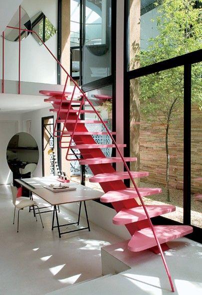 Ambiente moderno com escada colorida de ferro e corrimão de ferro