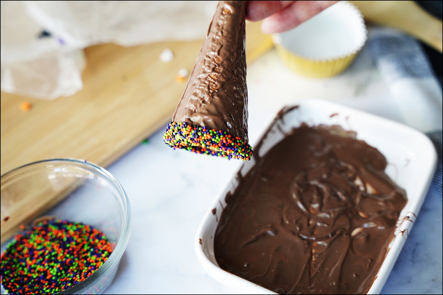 Dip the open end of the cone in a bowl of sprinkles and set aside on wax paper to harden. 