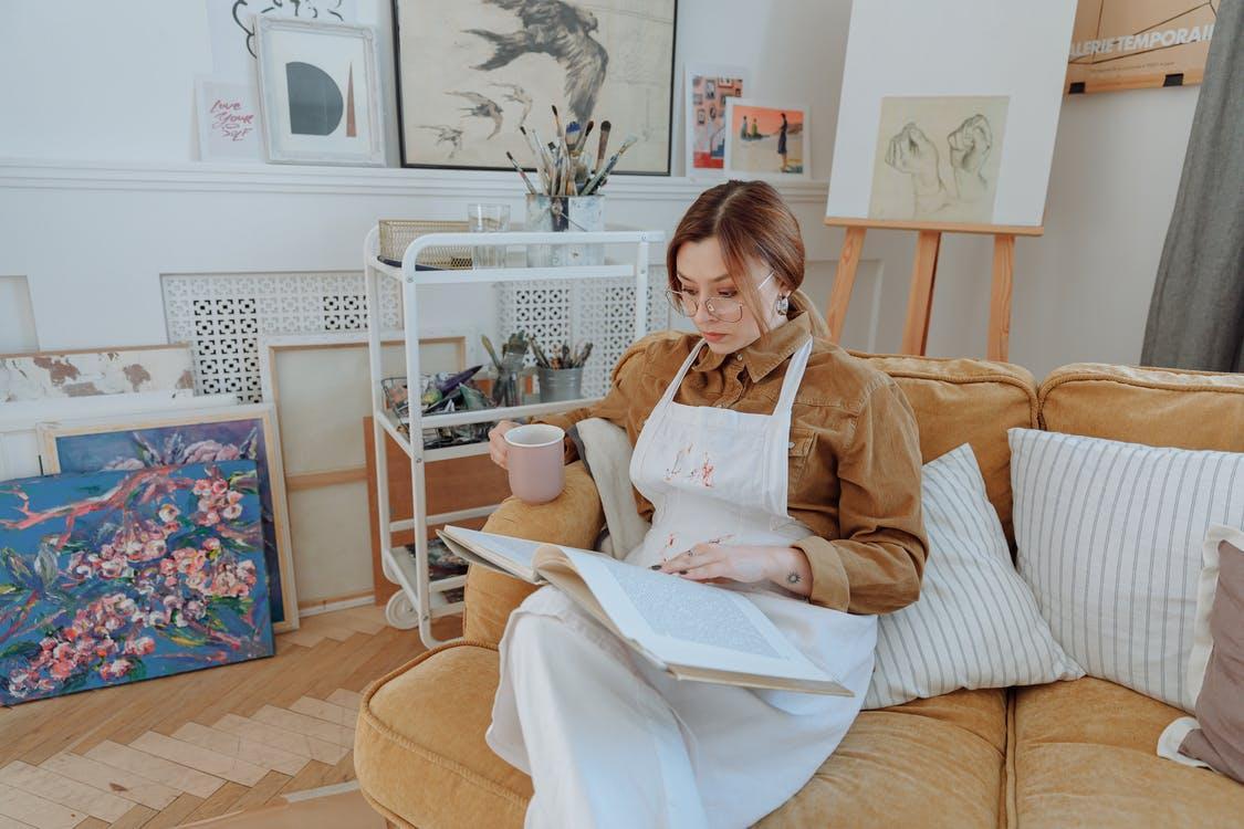 Woman Wearing White Apron Reading a Book